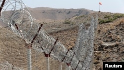 FILE - A view of the border fence outside the Kitton outpost on the border with Afghanistan in North Waziristan, Pakistan, Oct. 18, 2017.