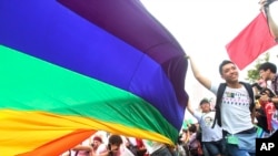 FILE - Participants revel through a street during a gay and lesbian parade in Taipei, Taiwan.