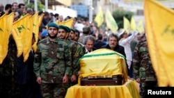 Brothers of top Hezbollah commander Mustafa Badreddine, who was killed in an attack in Syria, mourn over his coffin during his funeral in Beirut&#39;s southern suburbs, Lebanon, May 13, 2016