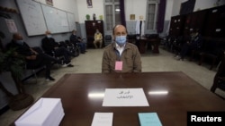 Un électeur portant un masque facial pour se protéger contre le COVID-19, lors du référendum constitutionnel à Alger, en Algérie, le 1er novembre 2020.