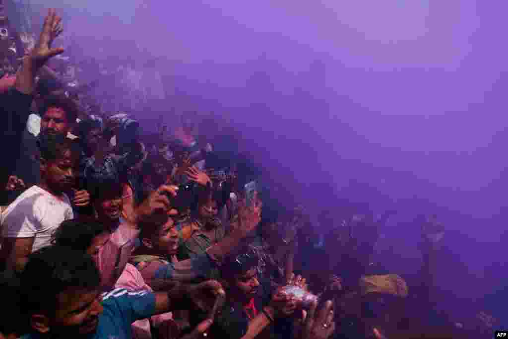 Hindu devotees smeared with colored powder, gather as they celebrate 'Masaan' or 'Bhasma' Holi along the banks of the river Ganges at Manikarnika Ghat in Varanasi, India.