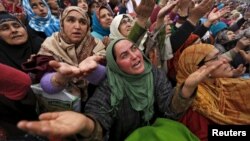 FILE - Kashmiri Muslims women react upon seeing a relic believed to be hair from the beard of Prophet Mohammed, being displayed on the Friday following the festival of Eid-e-Milad-ul-Nabi at Hazratbal shrine in Srinagar, India, Jan.1, 2016.