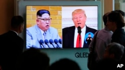 FILE - People watch a TV screen showing file footage of U.S. President Donald Trump, right, and North Korean leader Kim Jong Un during a news program at the Seoul Railway Station in Seoul, South Korea, April 21, 2018.
