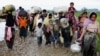 A group of Rohingya refugees walk on the muddy road after traveling over the Bangladesh-Myanmar border in Teknaf, Bangladesh, Sept. 1, 2017.
