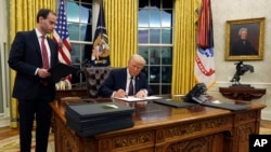 President Donald Trump signs an executive order withdrawing the U.S. from the World Health Organization in the Oval Office of the White House, Jan. 20, 2025, in Washington.