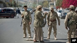 Shi'ite Yemeni Houthi, wearing army uniforms stand guard on a street leading to the presidential palace in Sana'a, Jan. 21, 2015.