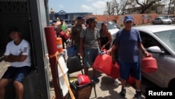 People queue at a gas station to fill up their fuel containers, after the island was hit by Hurricane Maria, in San Juan, Puerto Rico, Sept. 28, 2017.