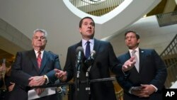 FILE - In this Oct. 24, 2017, file photo, House Intelligence Committee Chairman Rep. Devin Nunes, R-Calif., center, standing with Rep. Peter King, R-N.Y., left, and Rep. Ron DeSantis, R-Fla., right, speaks on Capitol Hill in Washington.