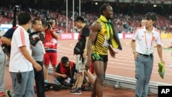 Jamaica's Usain Bolt walks away after being hit by a videographer on a Segway as Bolt celebrated winning the men’s 200m final at the World Athletics Championships at the Bird's Nest stadium in Beijing, Aug. 27, 2015.