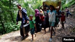 Rohingya people walk toward the makeshift shelter near the Bangladesh-Myanmar border in Cox’s Bazar, Bangladesh, Aug. 28, 2017.