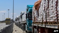 মিশরীয় দিকের রাফাহ সীমান্ত ক্রসিংয়ের বাইরে গাজার জন্য মানবিক ত্রাণ বহনকারী মিশরীয় ট্রাকগুলি সারিবদ্ধভাবে আটকে রয়েছে । ফটোঃ ২৩ মার্চ, ২০২৪। 