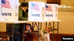 Para pemilih memasukkan surat suara di tempat-tempat pemungutan suara pada Hari Pemilu di Jeffersontown, Kentucky, 3 November 2020. (Foto: Bryan Woolston/Reuters)