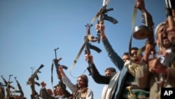 FILE - Tribesmen loyal to Houthi rebels hold up their weapons in a show of support for peace talks in Sanaa, Yemen. The U.S. House on Feb. 13, 2019, approved a resolution that would end U.S. support for the Saudi-led coalition in the war in Yemen.