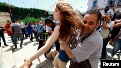 Police officers detain an activist from the women's rights group FEMEN during a protest against the arrest of their Tunisian member named Amina Sboui, in front of Tunisia's Ministry of Justice in Tunis, May 29, 2013.