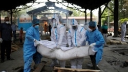 ក្រុមបុគ្គលិកសុខាភិបាលដែលស្ថិតក្នុងឯកសណ្ឋានការពារពីជំងឺឆ្លងកូវីដ១៩ កំពុងលើកសាកសពជនរងគ្រោះដោយសារជំងឺកូវីដដាក់កន្លែងបូជាសព នៅក្រុងញូវដេលី ប្រទេសឥណ្ឌា កាលពីថ្ងៃទី ២១ ខែមេសា ឆ្នាំ ២០២១។