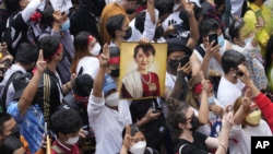 Myanmar nationals living in Thailand hold a picture of former Myanmar leader Aung San Suu Kyi during protest marking the two-year anniversary of the military takeover that ousted her government outside the Myanmar Embassy in Bangkok, Thailand, Feb. 1, 2023. 