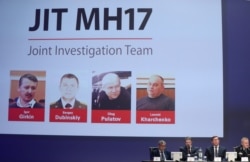 Russian nationals Igor Girkin, Sergey Dubinskiy and Oleg Pulatov, and Ukrainian Leonid Kharchenko, accused of downing of flight MH17, seen on screen as international investigators present their findings, in Nieuwegein, Netherlands, June 19, 2019.