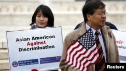 FILE - Asian-American demonstrators hold a rally outside the U.S. Supreme Court as it was hearing a case involving affirmative action in university admissions, Dec. 9, 2015. The case was brought white applicant Abigail Fisher, who claimed that a University of Texas policy caused her to be rejected in favor of less qualified blacks and Hispanics. In a twist on the Fisher case, a lawsuit against Harvard asserted that Asian-Americans have been particularly hurt by affirmative action programs in university admissions. 