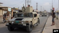 An Iraqi army vehicle patrols after a car bomb attack on Oct. 23, 2018, killed six people and wounded 26 more at a market in Al Qayyarah, located south of the Islamic State group's former Iraqi capital of Mosul.