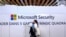 FILE - A woman walks in front of the Microsoft stand during a cybersecurity conference in Lille, France, Jan. 29, 2020. 