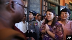 Mahasiswi Myanmar, Chaw Sandi Tun (25 tahun), berbicara dengan seorang pendeta Budha setelah sidang di pengadilan di kota Maubin, Myanmar, Selasa (24/11)