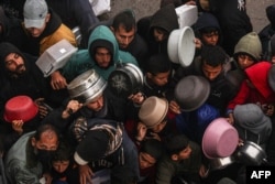 Palestinians receive food rations at a donation point at a camp for internally displaced people in Rafah, Gaza Strip, on Feb. 2, 2024.