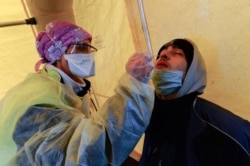 A man undergoes a rapid antigen test for COVID-19 after the evacuation by French Gendarmes of the last partygoers who attended a rave in a disused hangar in Lieuron, Jan. 2, 2021.