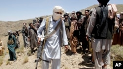 Anggota faksi Taliban yang memisahkan diri berjalan dalam sebuah rapat di distrik Shindand, di Provinsi Herat, Afghanistan, 27 Mei 2016.