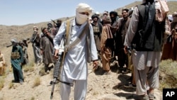 FILE - Members of a Taliban breakaway faction walk during a gathering, in Shindand district of Herat province, Afghanistan, May 27, 2016.