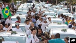 Taxi drivers block a street to protest the Uber ride-sharing service outside city council headquarters in downtown Sao Paulo, Brazil, Sept. 9, 2015.