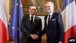 Прем’єр-міністр Чеської Республіки Петр Фіала тисне руку президенту Франції Еммануелю Макрону під час візиту французького лідера до Праги, 5 березня 2024 року. (Фото Людовіка МАРІНА / AFP)