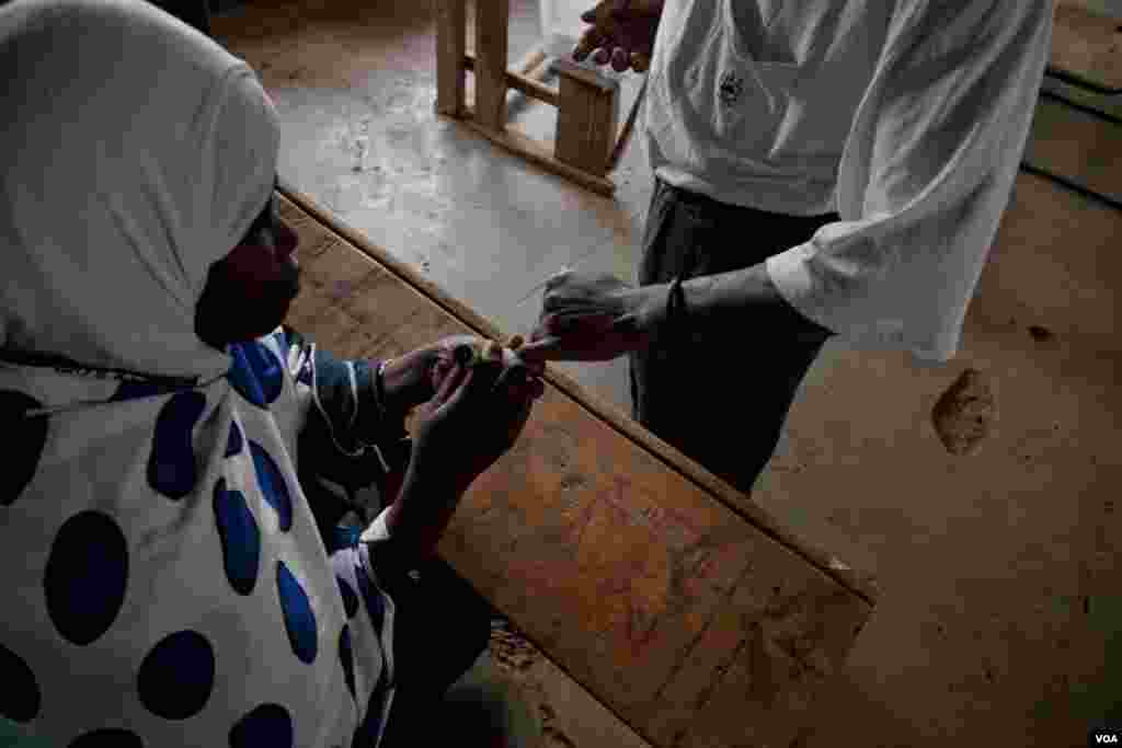 An IEBC official inks a voter's finger after he cast his ballot, March 4, 2013. (R. Gogineni/ VOA)