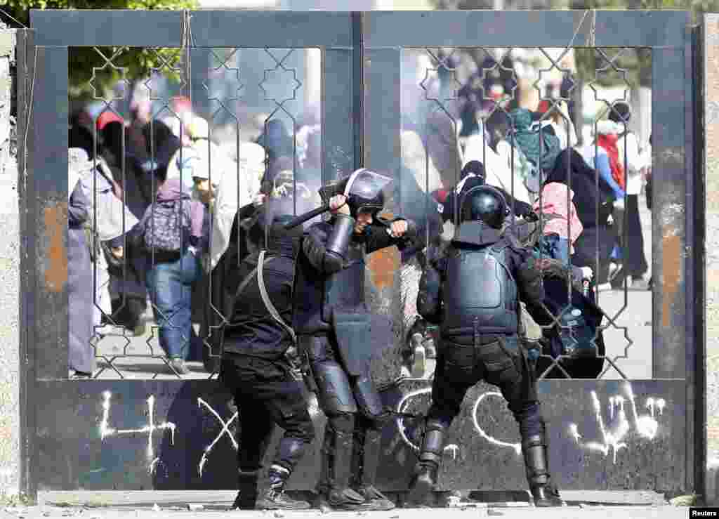 Polisi Mesir berusaha mendobrak pintu masuk di Universitas Al-Azhar, Kairo dalam bentrokan dengan para mahasiwa pendukung kelompok Ikhwanul Muslimin&nbsp;