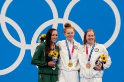 Gold medalist Lydia Jacoby, center, of the U.S., stands with silver medalist Tatjana Schoenmaker, left, of South Africa, and bronze medalist Lilly King, of the U.S., after the final of the women's 100-meter breaststroke.