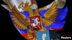 FILE - A Russian flag and a 3-D model of the Facebook logo are seen through a cutout of the Twitter logo in this photo illustration taken in Zenica, Bosnia and Herzegovina, May 22, 2015.
