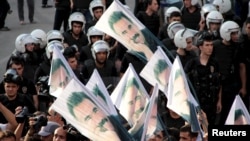 FILE - Demonstrators hold flags picturing imprisoned Kurdish rebel leader Abdullah Ocalan, during a protest against latest security operations in Diyarbakir, Turkey, Sept. 6, 2015.