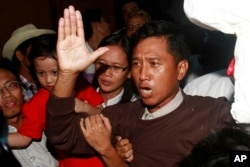 FILE - Kyaw Min Yu, a pro-democracy activist talks to journalists as he arrives at Yangon airport welcomed by his wife Nilar Thein, background, also an activist and his daughter after being released from a prison on Jan. 13, 2012, in Yangon, Myanmar.