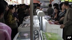 Warga Korea melihat-lihat produk mesin cuci buatan perusahaan China dalam pameran di Pyongyang. (Foto: Dok)