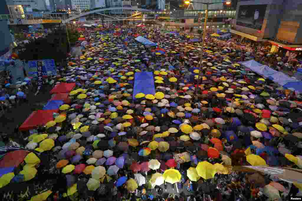 Para demonstran membuka payung mereka, simbol dari gerakan pro-demokrasi, dalam peringatan satu bulan sejak mereka turun ke jalan, di distrik keuangan Hong Kong (28/10). (Reuters/Damir Sagolj) 