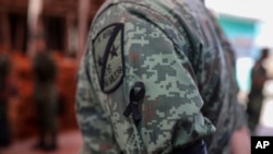 A Mexican soldier wears a black ribbon during the wake for Alfredo Gonzalez Munoz, a fellow soldier who died in a gun battle in the city of Culiacan between drug cartel gunmen and members of the army and the police, in Veracruz, Mexico, Oct. 19, 2019.