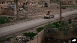 A Humvee drives in a village recently retaken from Islamic State militants by U.S.-backed Syrian Democratic Forces near Baghouz, Syria, Feb. 17, 2019.