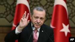 Turkey's President Recep Tayyip Erdogan gestures as he addresses local administrators, in Ankara, Turkey, Wednesday, Feb. 8, 2017. In a sign of ameliorating ties, Turkish officials said Wednesday that U.S. President Donald Trump looked "positively" on two