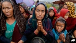 Seorang perempuan desa bernama Ramaya, bertepuk tangan saat antri untuk mendapatkan bantuan makanan, sesaat setelah helikopter yang mengangkut bantuan tersebut mendarat di desa terpencil Gumda, dekat pusat gempa di idstrik Gorkha, Nepal, 29 April 2015 (Foto: dok). 