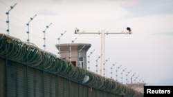 FILE - Security cameras are seen above the perimeter fence of a facility critics call a re-education camp for Uighurs, in Dabancheng, in Xinjiang Uighur Autonomous Region, China, Sept. 4, 2018. 