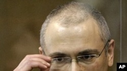 Former Yukos CEO Mikhail Khodorkovsky stands behind a glass wall at a court in Moscow, Russia, May 24, 2011