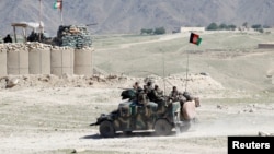 FILE - Afghan special forces patrol in Pandola village near the site of a U.S. bombing in the Achin district of Nangarhar province in eastern Afghanistan, April 14, 2017.
