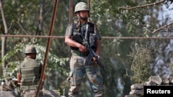 Indian army soldiers keep guard on top of a shop along a highway on the outskirts of Srinagar, Sept. 29, 2016. 