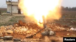 FILE - A Free Syrian Army fighter fires a shell toward Islamic State fighters in the northern Aleppo countryside, Syria.