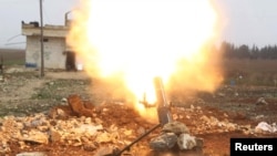 FILE - Free Syrian Army fighter fires a shell toward Islamic State fighters in the northern Aleppo countryside, Syria. U.S. Secretary of Defense Ash Carter said Friday that "sharing and fusing" information across the battlefield is helping restrict foreign fighters' movements.