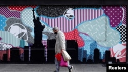 A man wears a protective face mask as he walks past closed stores, during the outbreak of the coronavirus disease (COVID-19), in Manhattan, New York City, New York, May 11, 2020. 